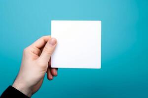 empty white blank mockup in hand on blue background photo