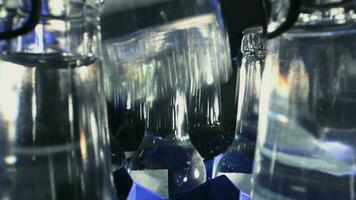 Reihe von klar Glas Flaschen mit Mineral Wasser organisiert im Plastik Container mit Hand pflücken oben einer Flasche. video