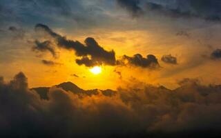 Beautiful dramatic sunset sky over mountain with clouds photo