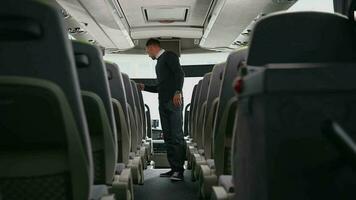 autobús conductor mirando alrededor comprobación limpiar el polvo apagado pasajeros asientos y inspeccionando interior de vehículo después terminado cambio. video