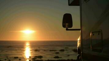 campeur van moteur Accueil dans de face de le mer pendant le coucher du soleil video