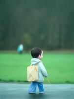 Child with raincoat and backpack. Concept of back to school. photo