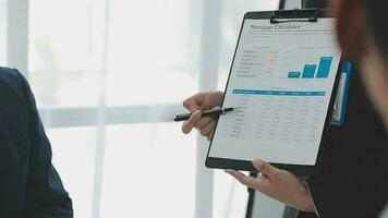 Financial analysts analyze business financial reports on a digital tablet planning investment project during a discussion at a meeting of corporate showing the results of their successful teamwork. video