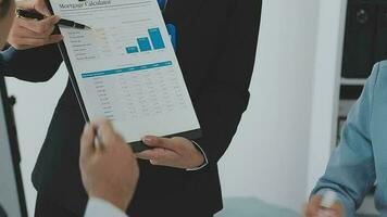 Financial analysts analyze business financial reports on a digital tablet planning investment project during a discussion at a meeting of corporate showing the results of their successful teamwork. video