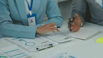 Financial analysts analyze business financial reports on a digital tablet planning investment project during a discussion at a meeting of corporate showing the results of their successful teamwork. video