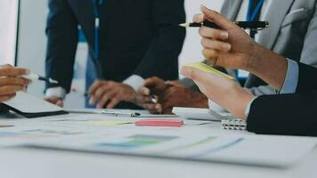 Gruppe von Mitarbeiter im formal tragen Sitzung beim Tabelle im Konferenz Zimmer und streiten Über Projekt von Unternehmen Entwicklung während Treffen video