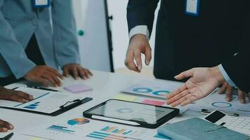 Gruppe von Mitarbeiter im formal tragen Sitzung beim Tabelle im Konferenz Zimmer und streiten Über Projekt von Unternehmen Entwicklung während Treffen video