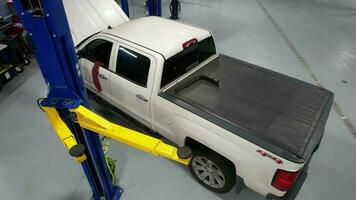 Pickup Truck on an Automotive Lift Inside Authorized Auto Service. Scheduled Car Maintenance. video