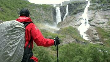 naturskön vattenfall trailheaden och de caucasian vandrare med ryggsäck. långsam rörelse video