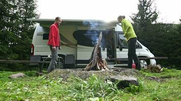 Pareja haciendo hoguera en frente de su rv camper camioneta video