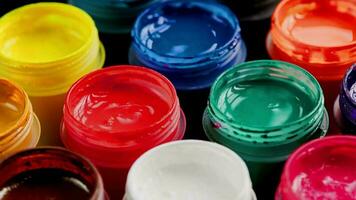 loopable rotating close-up background of opened small gouache paint jars video