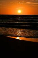 naranja puesta de sol en el playa de el báltico mar en Polonia foto