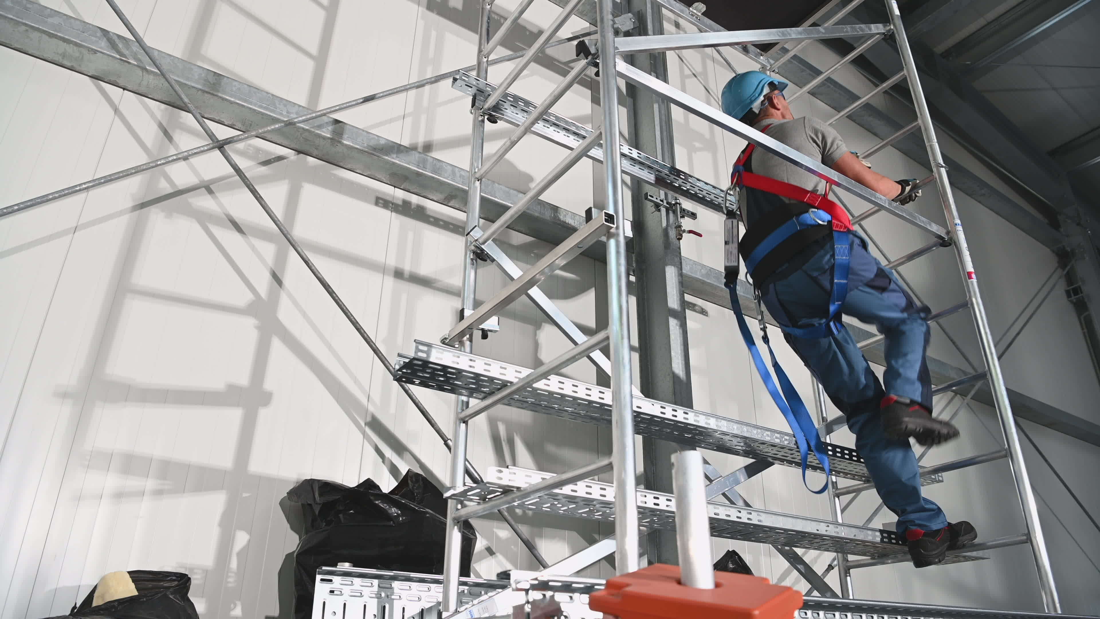Contractor Worker Wearing Safety Harness Going Up Using Scaffolding
