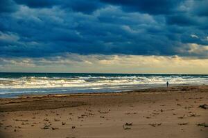 beach by the sea and a lonely runner on the shore landscape photo