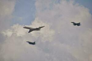 flying combat aircraft against the blue sky with clouds on a sunny day photo