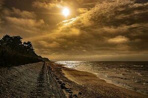 pintoresco calma puesta de sol con vistoso nubes en el costas de el báltico mar en Polonia foto