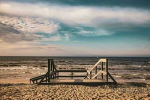 playa paisaje con de madera escalera líder a el playa foto