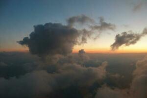 misterioso puesta de sol con nubes desde el avión ventana con foto