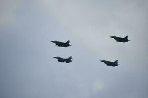 flying combat aircraft against the blue sky with clouds on a sunny day photo