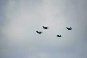 flying combat aircraft against the blue sky with clouds on a sunny day photo