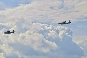 flying combat aircraft against the blue sky with clouds on a sunny day photo