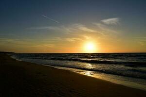 naranja puesta de sol en el playa de el báltico mar en Polonia foto