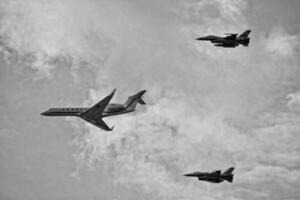 flying combat aircraft against the blue sky with clouds on a sunny day photo