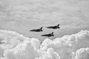 flying combat aircraft against the blue sky with clouds on a sunny day photo