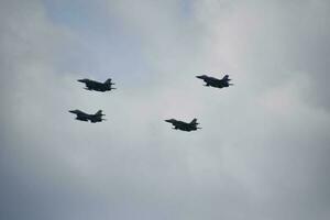 flying combat aircraft against the blue sky with clouds on a sunny day photo