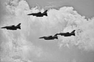 flying combat aircraft against the blue sky with clouds on a sunny day photo