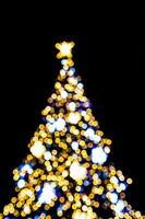 blurred lights illuminating the Christmas tree on a black background photo