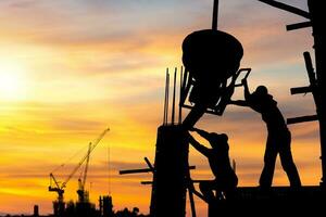 silueta de ingeniero y trabajador equipo comprobación proyecto a edificio sitio fondo, construcción sitio con puesta de sol en noche hora antecedentes foto