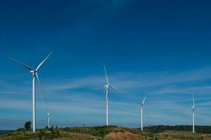 Wind turbines generating electricity over blue sky photo