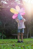 retrato de niño niña jugando con vistoso juguete globos en el parque al aire libre. foto