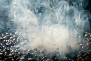 Coffee beans roasting with smoke,  selective focus, and soft focus. photo