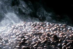 Coffee beans roasting with smoke,  selective focus, and soft focus. photo