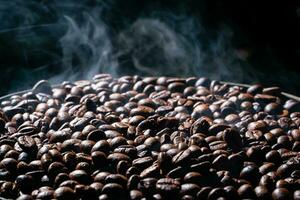 Coffee beans roasting with smoke,  selective focus, and soft focus. photo