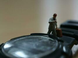 Bogor, Indonesia - 2018. a miniature figure of an office worker walking on a watch. photo