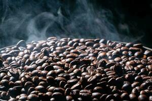 Coffee beans roasting with smoke,  selective focus, and soft focus. photo