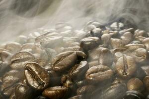 Coffee beans roasting with smoke,  selective focus, and soft focus. photo