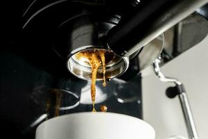 Close-up of espresso pouring from a coffee machine, inside the house,  Close-up of espresso pouring from a coffee machine, inside the house photo