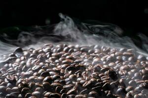 Coffee beans roasting with smoke,  selective focus, and soft focus. photo