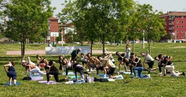 Bologna  Italy- May 7, 2023 Group of people practicing yoga in a city park of Bologna. Italy. photo