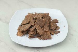 banana chips with cocoa powder served on a white plate photo