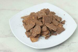 banana chips with cocoa powder served on a white plate photo