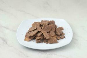 banana chips with cocoa powder served on a white plate photo