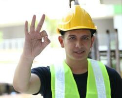 South East Asian young Malay Chinese man woman wearing safely helmet construction site work photo