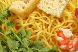 Fresh yellow egg noodle prawn tofu coriander leaf on whit background photo