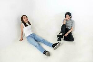 grupo de joven sur este asiático mezclado mujer chino malayo sentar en blanco antecedentes piso relajarse hablar risa foto