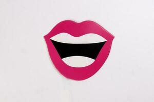 Red lips white teeth black open smiley mouth shape paper die cut selfie portrait party fun paper prop sticker stick on white background photo